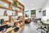 Modern open-plan apartment featuring a stylish wooden bookshelf divider, chic living area with a tan leather sofa, and a cozy dining space with natural light.