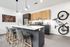 Sleek kitchen with modern appliances, stylish pendant lighting, and a welcoming island with seating, complemented by a trendy bicycle wall mount and artistic decor.