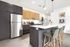 Modern kitchen with sleek cabinetry, stainless steel appliances, and a chic island featuring comfortable bar stools.