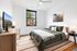 Bright and inviting bedroom with a modern design, featuring a cozy bed, stylish dresser, and large window offering natural light and serene views.