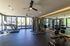 Modern fitness center with state-of-the-art treadmills, weight machines, and expansive windows offering a bright, inviting workout space.