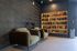 Chic apartment lobby with plush green armchairs and an elegant bookshelf, perfect for relaxation and reading.