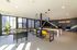Bright and modern game room featuring foosball, stylish seating, and vibrant yellow chairs under sleek pendant lighting.