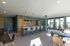 Modern communal kitchen with sleek countertops, stylish bar seating, and abundant natural light through large windows.