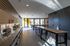 Contemporary common area with sleek countertops, ample natural light, and modern high stools, perfect for gatherings.