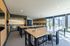 Bright and modern communal workspace with sleek high-top tables, large windows, and ample natural light.