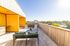 Inviting rooftop patio with vibrant yellow walls, modern seating, and stunning panoramic views.