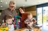 Happy family enjoying creative time together in a bright, modern apartment. Parents and children engaged with colorful arts and crafts in a sunlit room.