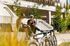 Two bikers in helmets relaxing on stylish concrete steps with bicycles in a sunny urban setting.
