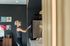 Modern interior space with a stylish kitchenette featuring a coffee machine. Cozy atmosphere enhanced with dark walls and a record shelf.