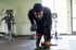Focused individual performing dumbbell rows in a modern gym, showcasing fitness and determination.