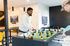 Modern recreational room with stylish wallpaper and a foosball table, offering a vibrant and social atmosphere.