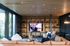 Modern living room with cozy seating, large windows for natural light, and a spacious entertainment area.