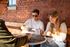 Vibrant social scene with friends enjoying coffee in a cozy, rustic brick-walled cafe setting.