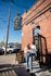 Charming brick coffee shop with decorative string lights, featuring patrons enjoying a sunny day outside.