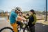Joyful family time at the park with a father and child on a bicycle, sharing smiles and laughter on a sunny day.