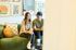 Inviting living room scene with a couple relaxing on a stylish green sofa, surrounded by modern art and cozy decor.