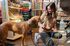 Engaging pet store moment with a friendly dog sniffing a treat held by a smiling woman, surrounded by colorful product displays.