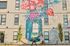 Vibrant apartment exterior featuring large floral mural, colorful design, and modern architecture.