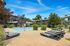 Inviting outdoor pool area with stylish lounge chairs and lush greenery at a modern apartment complex.