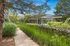 Charming outdoor pathway surrounded by lush greenery and modern architectural elements, creating a tranquil, nature-inspired retreat.