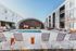 Modern apartment complex featuring a stylish outdoor pool area with sleek lounge chairs, surrounded by contemporary architecture and a unique curved pavilion.