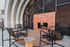 Modern outdoor patio with stylish metal chairs surrounding a sleek brick fireplace, perfect for cozy gatherings.