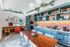 Chic kitchen and dining area featuring vibrant decor, open shelving, and lush greenery for a stylish and inviting atmosphere.