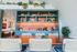 Chic modern dining area with a vibrant green and orange color scheme, featuring a stylish wooden table, designer chairs, and lush greenery accents.