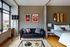 Chic urban studio with modern decor, featuring a cozy sofa, artistic wall art, and sleek skateboard display.