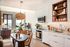 Chic open-plan kitchen and living area with modern decor, stylish lighting, and large windows offering stunning views.