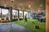 Vibrant fitness center with natural light, modern equipment, and cityscape views; features exercise zones and motivational ambiance.