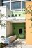 Modern apartment entrance with a bold green door, stylish URBY sign, and sunlit architectural details.