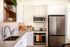 Contemporary kitchen with sleek stainless steel appliances, elegant marble countertop, and stylish open shelving.