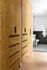 Chic apartment hallway with elegant wooden closets leading to a modern bathroom, exuding style and convenience.