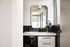 Chic modern bathroom with sleek black tiles, large mirror, and stylish vanity offering a luxurious feel.