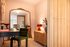 Chic apartment interior with a stylish mirror, elegant green chair, and ambient lighting, creating a warm and inviting atmosphere.