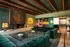 Luxurious living area with elegant green velvet sofas, modern art, and a sleek glass coffee table, exuding sophistication and style.