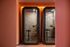 Contemporary office pods with vibrant orange accents, featuring sleek glass doors and modern seating for a productive workspace.