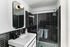 Sleek modern bathroom showcasing a stylish black and white tile design with a spacious glass shower and elegant vanity.