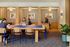 Vibrant and modern co-working space with wooden accents, cozy seating nooks, and lush indoor plants.
