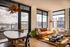 Chic apartment living room with floor-to-ceiling windows offering a stunning city view, featuring stylish furniture and elegant decor.
