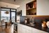 Modern kitchen with sleek cabinetry, built-in appliances, and a picturesque dining area with river view.