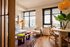 Chic apartment living room with stylish decor, featuring large windows with natural light and a cozy seating area.