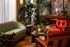 Chic living space featuring a stylish curved sofa, vibrant red armchairs, and lush indoor plants, creating a cozy and inviting ambiance.