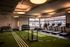 Modern fitness center with state-of-the-art equipment, featuring treadmills, weights, and a green turf area for versatile workouts.