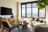 Bright and modern living room with expansive city views, featuring a cozy sofa, stylish armchair, and sleek glass coffee table.