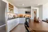 Modern kitchen featuring sleek white cabinets, stainless steel appliances, and elegant wood dining table with decorative accents.