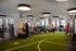 Vibrant modern gym with state-of-the-art equipment, bright lighting, and an indoor athletic turf area for dynamic workouts.
