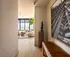 Elegant apartment entrance leading to a sunlit living room with modern decor and expansive city views.